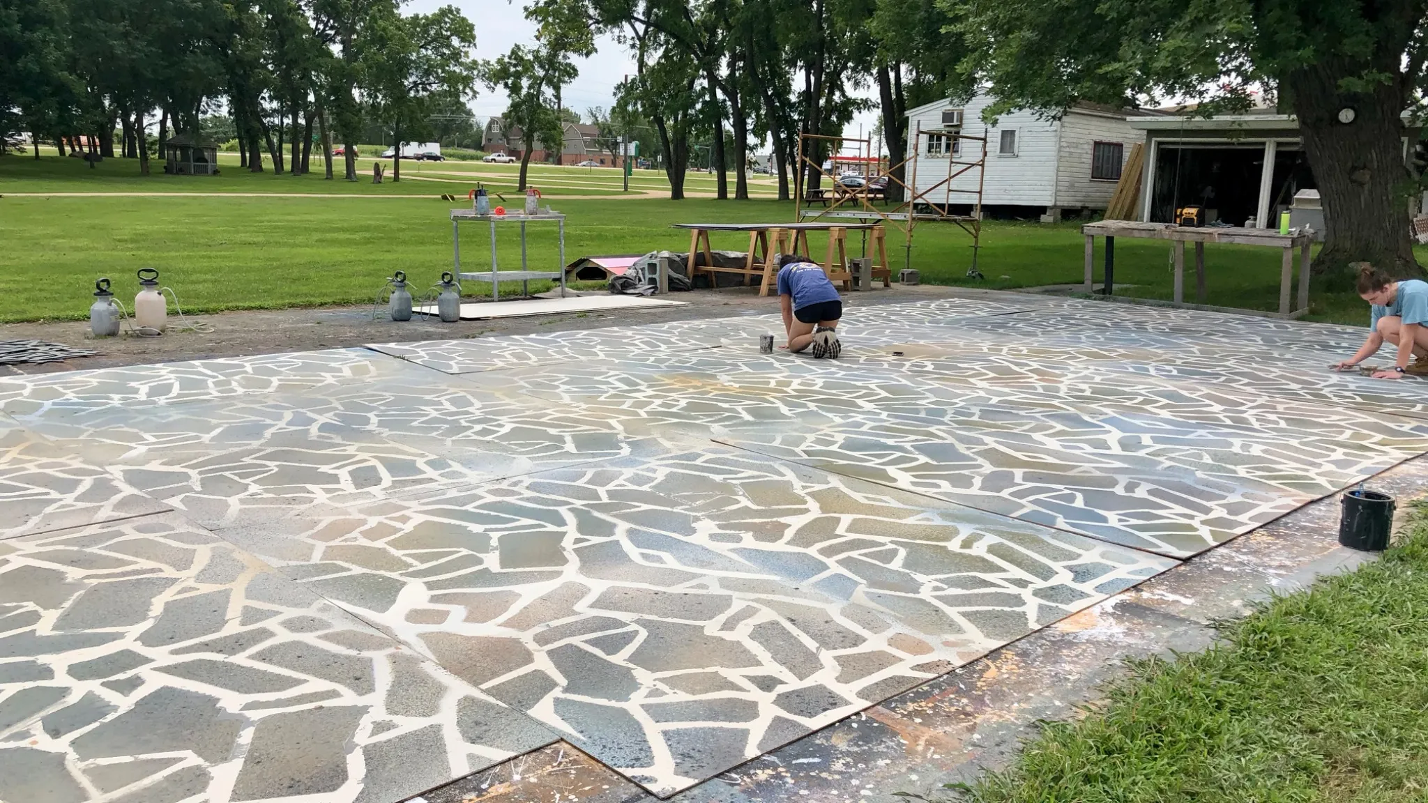 Scenic painting process for Mamma Mia at Okoboji Summer Theatre showing Grecian stone floor created with stencil and Hudson sprayer technique