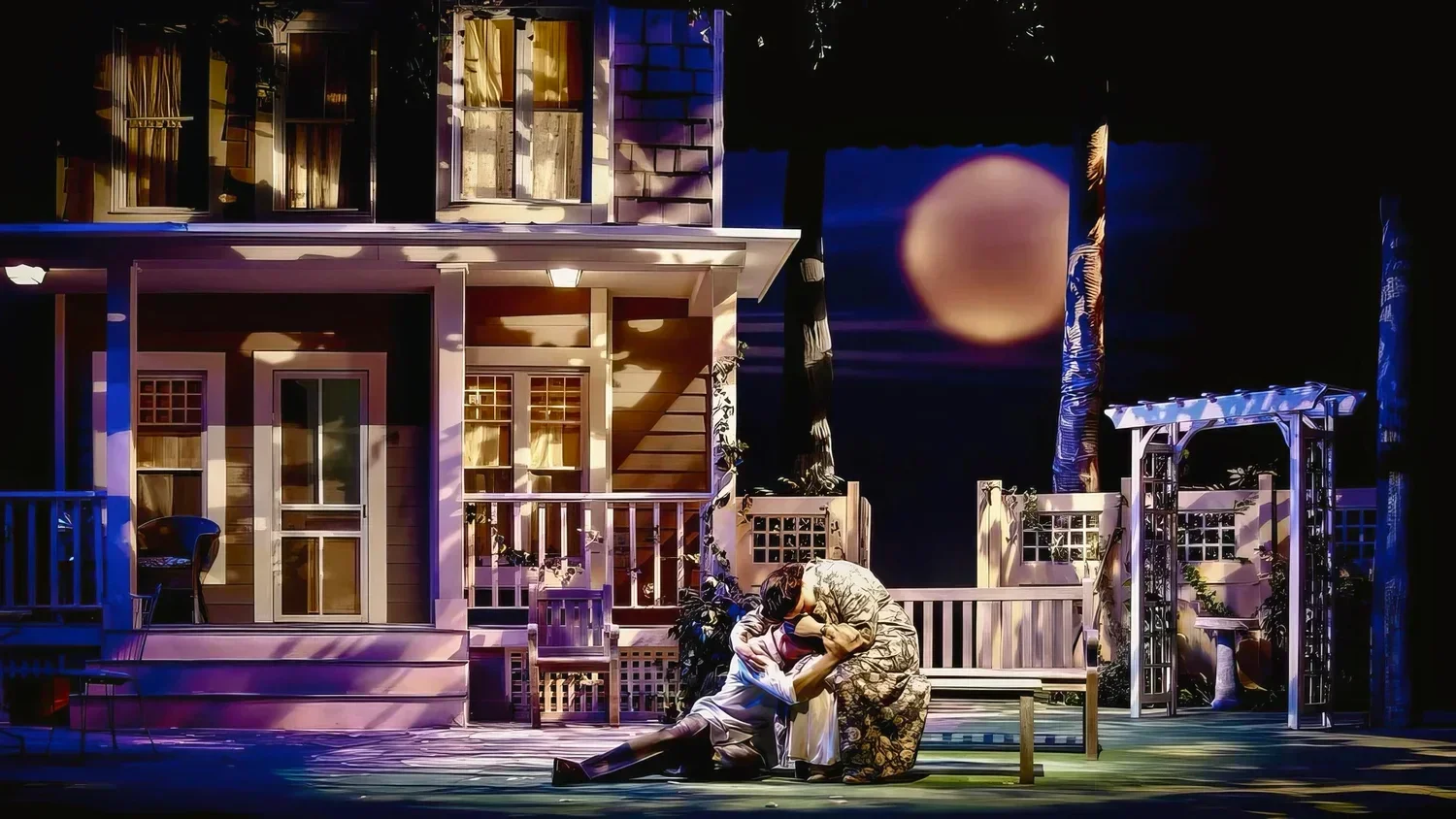 A domestic stage set for All My Sons with period furniture and tense family staging.