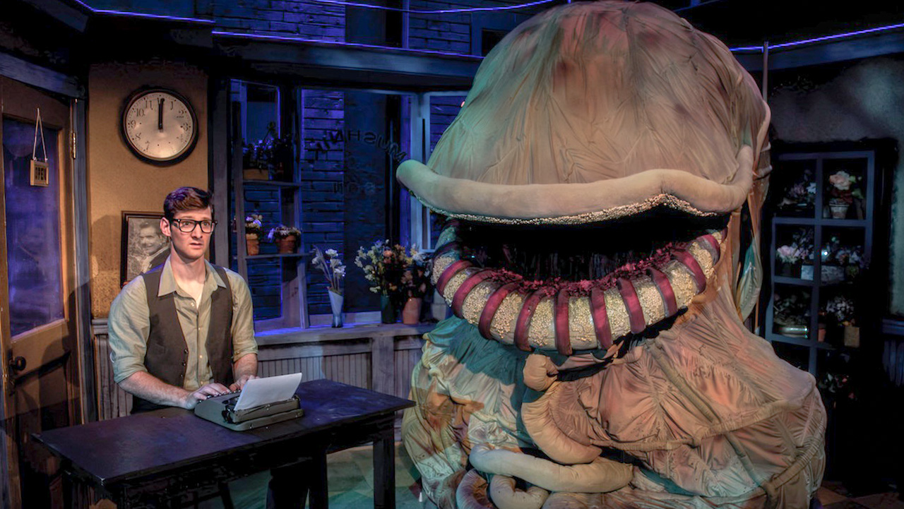 Production image from Little Shop of Horrors emphasizing the brick storefront and cramped scenic frame, scenic design by Brandon PT Davis.
