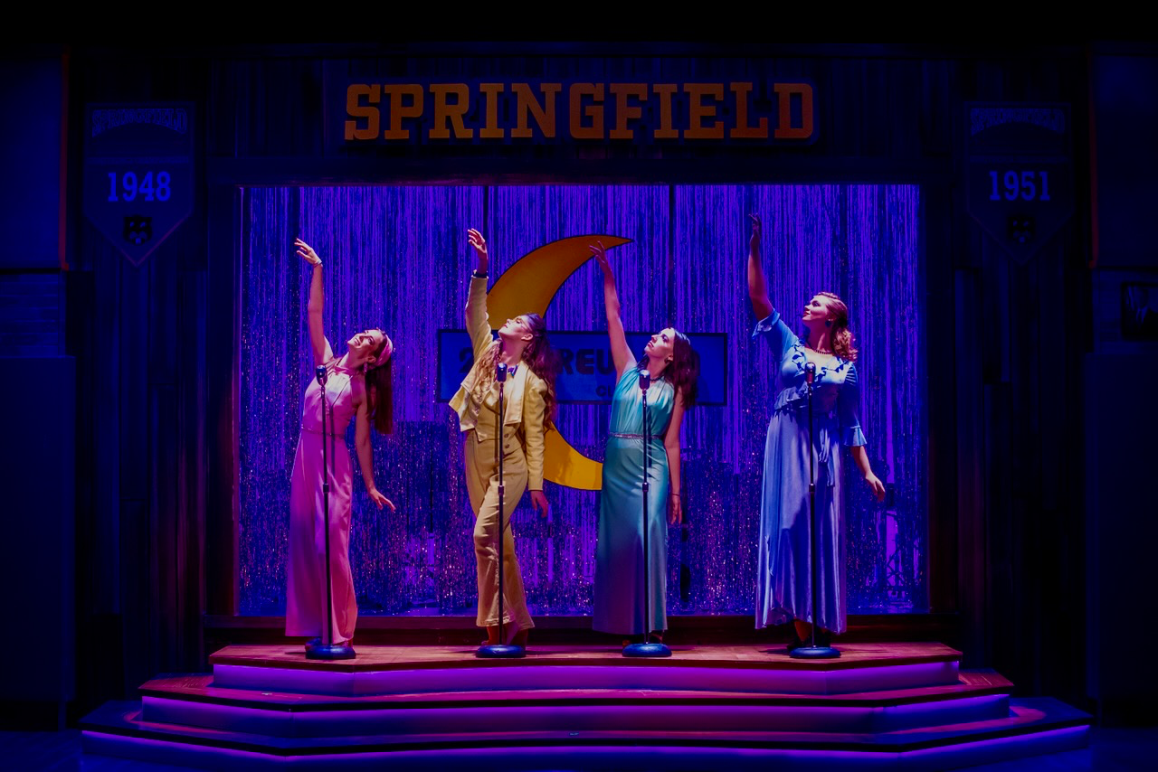 Production image from The Marvelous Wonderettes: Dream On showing the reunion gym stage, scenic design by Brandon PT Davis.