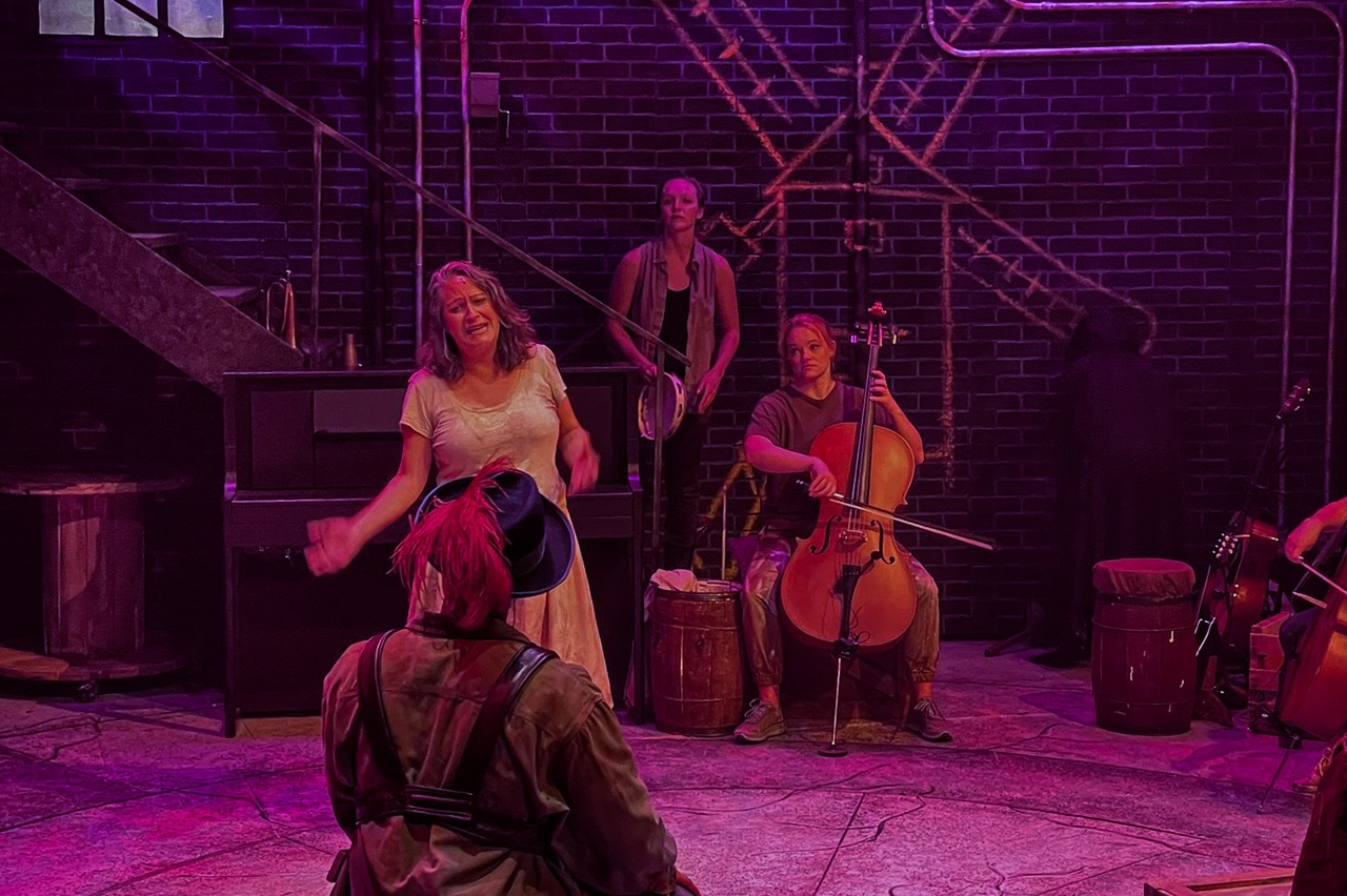 Final production image from The Man of La Mancha showing the full found-object warehouse environment, scenic design by Brandon PT Davis.