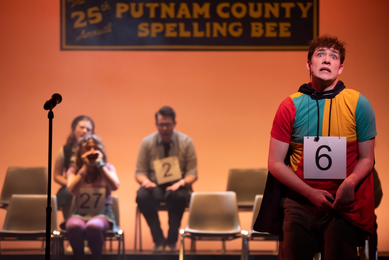 Performance image from Putnam County Spelling Bee showing the spelling platform and ensemble staging, scenic design by Brandon PT Davis.