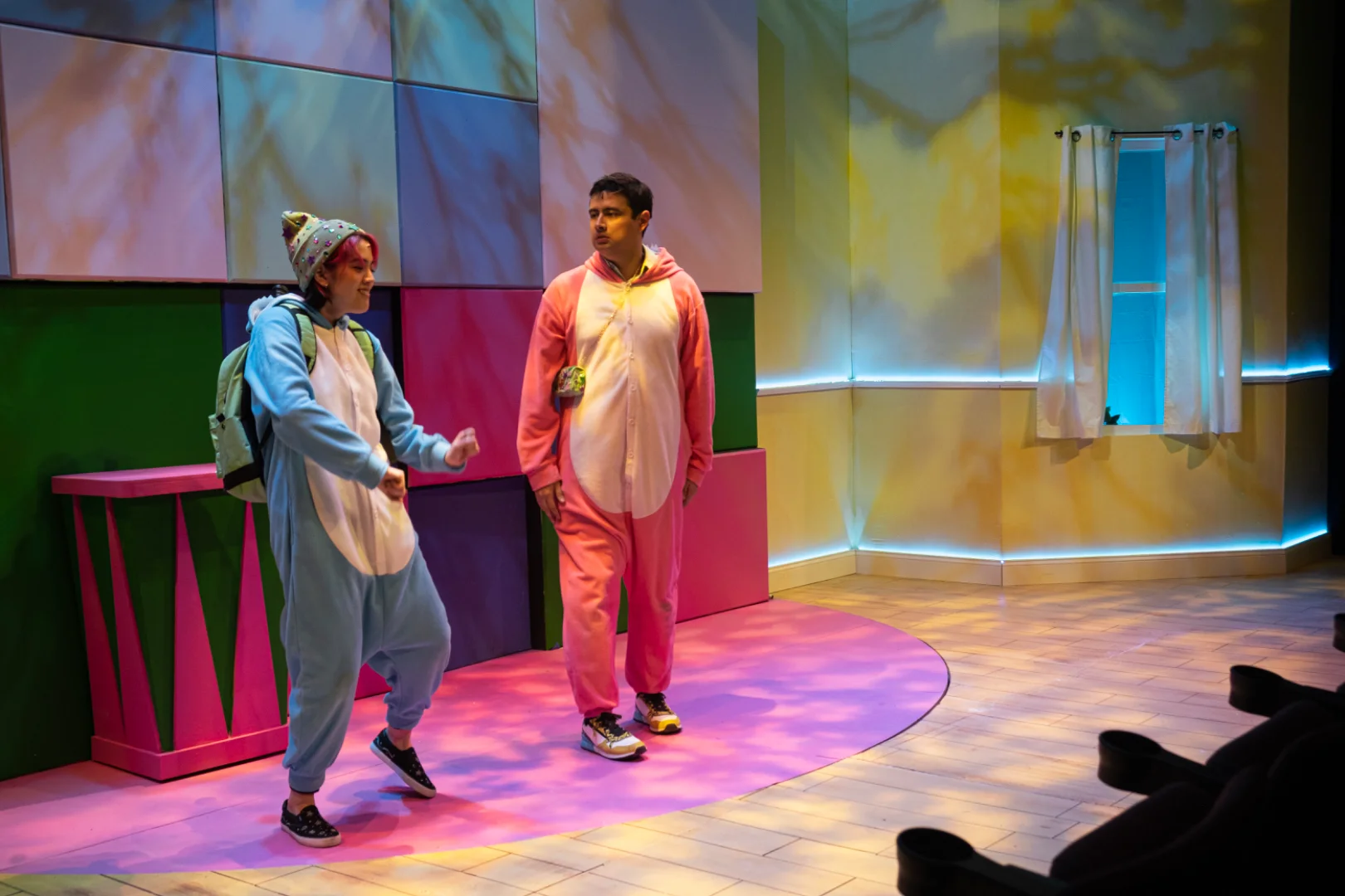 Performance image from ¡LOTERIA: GAME ON! with the family-room environment and central playing space, scenic design by Brandon PT Davis.