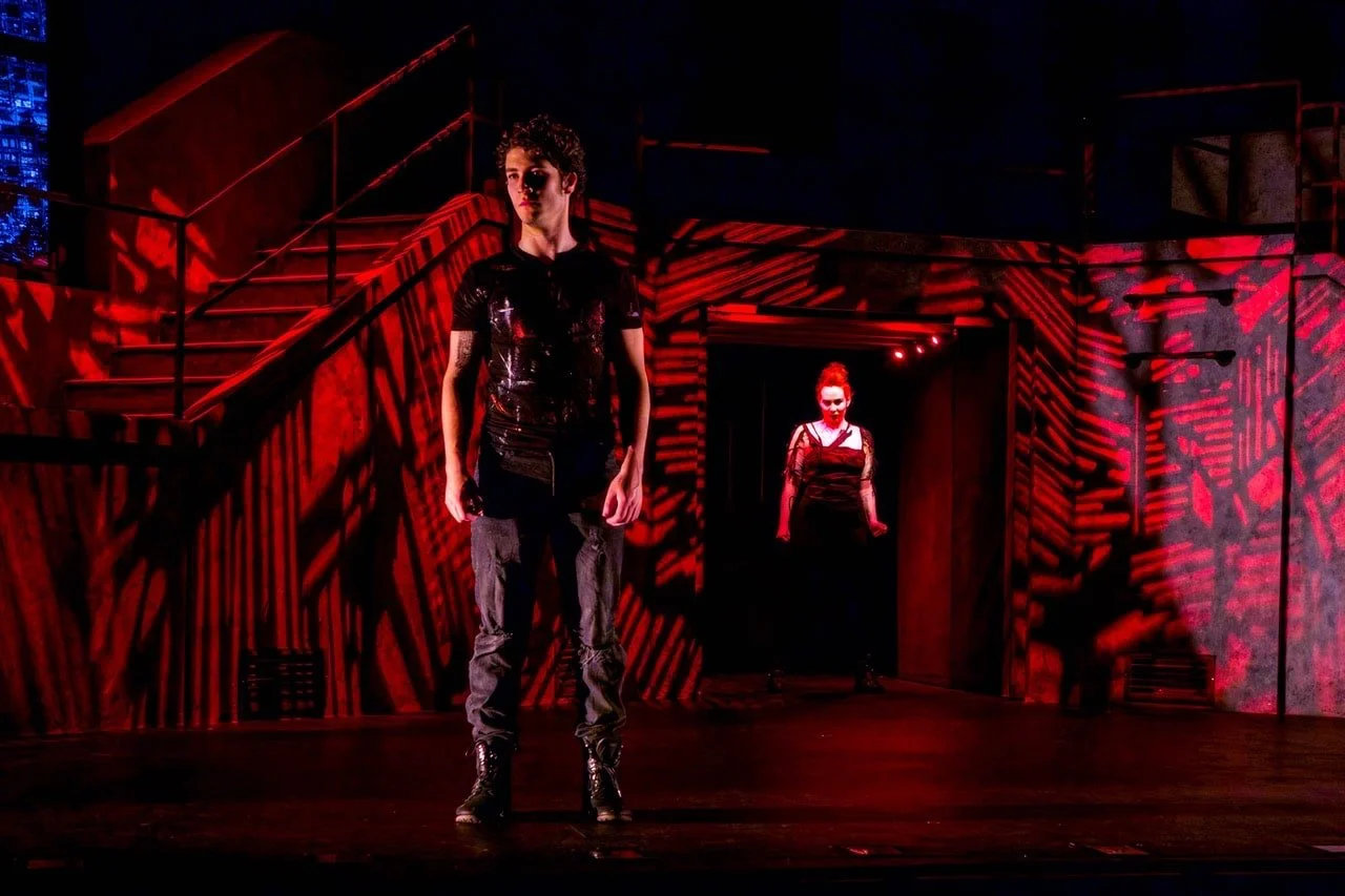 Production image from American Idiot highlighting the concrete framework and projection atmosphere, scenic design by Brandon PT Davis.