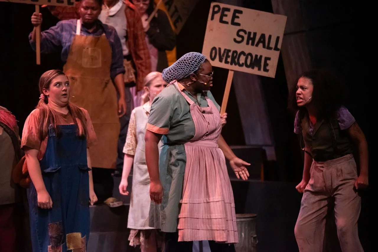 Stage picture from Urinetown emphasizing texture, levels, and ensemble composition, scenic design by Brandon PT Davis.