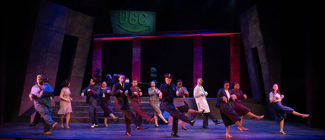 Cast moment on the industrial comic world of Urinetown, scenic design by Brandon PT Davis.