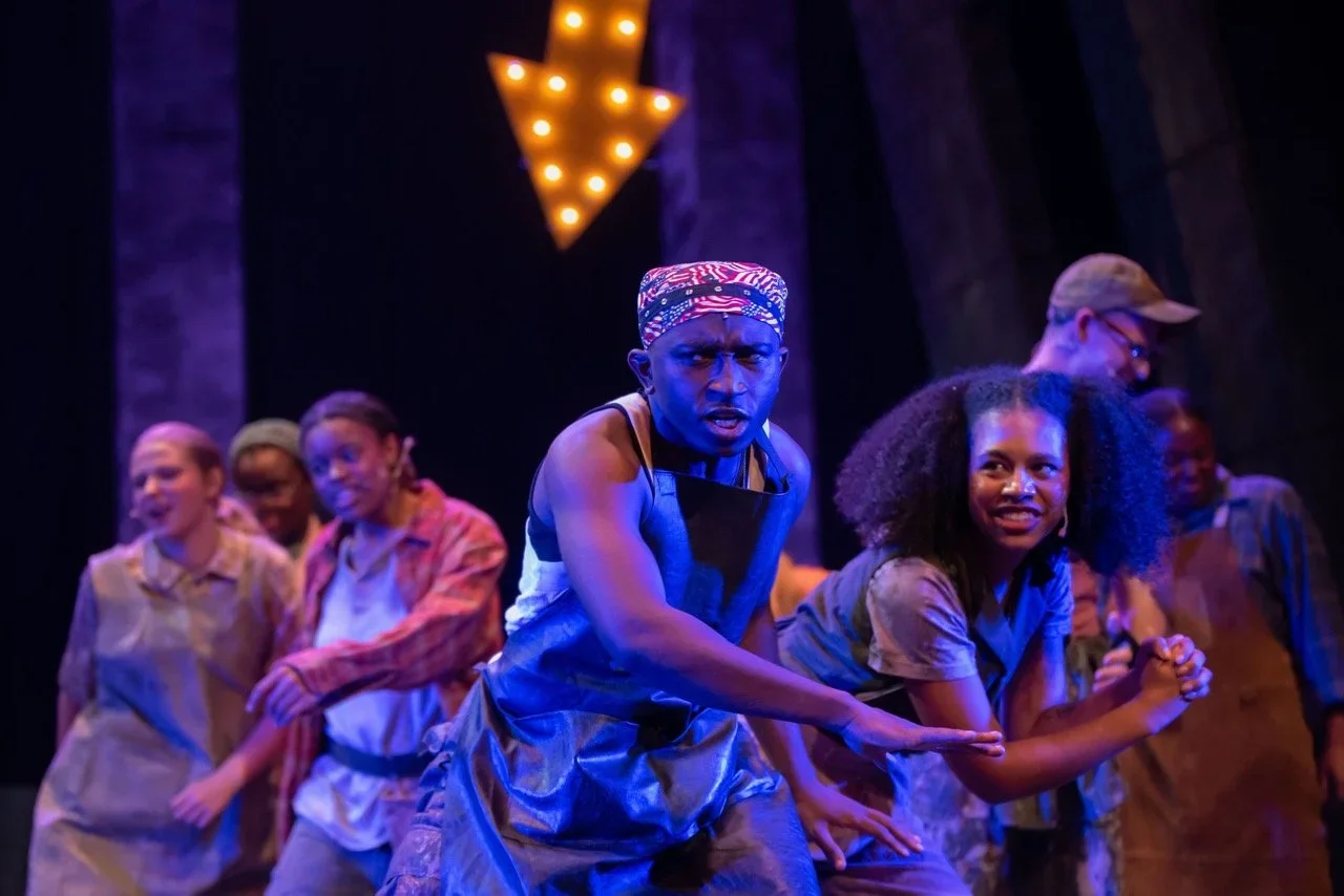 Production still of Urinetown highlighting ensemble traffic through the set, scenic design by Brandon PT Davis.