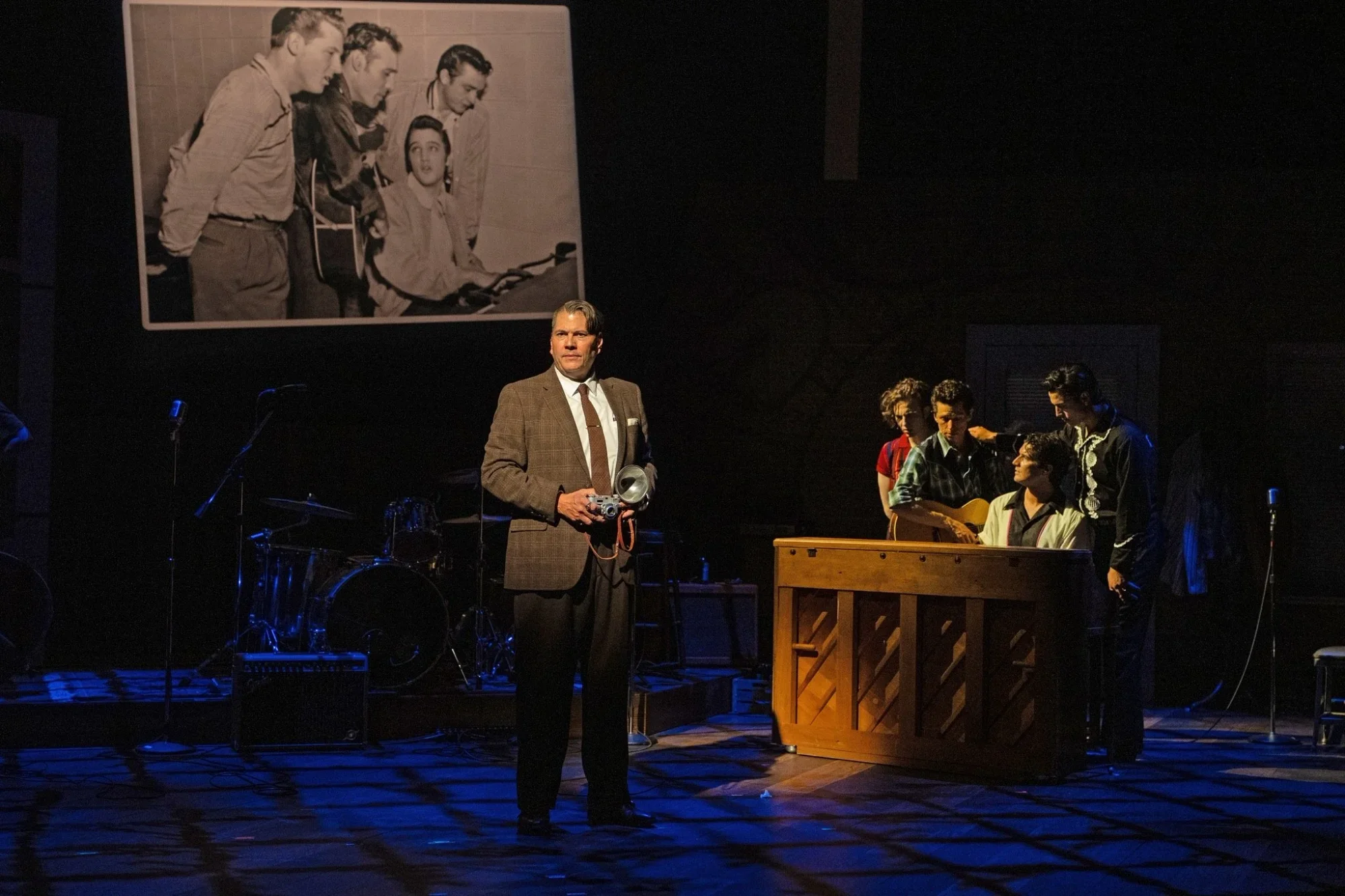 Band-centered stage composition with warm practical lighting in Million Dollar Quartet, scenic design by Brandon PT Davis.
