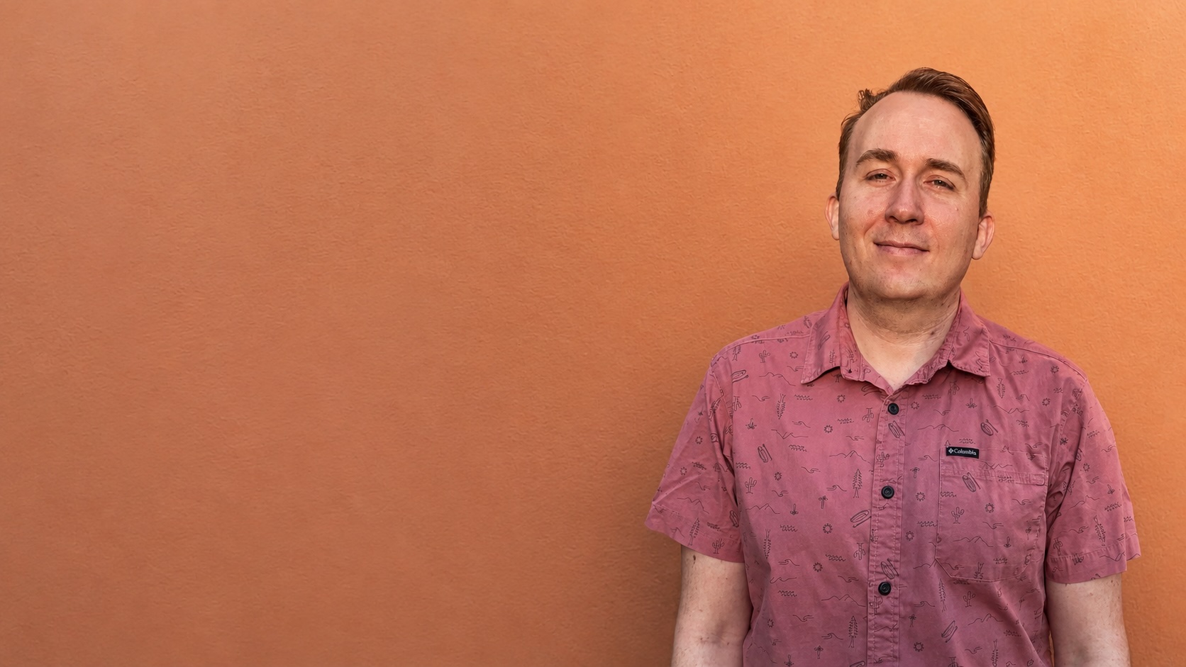 Brandon PT Davis against an orange wall
